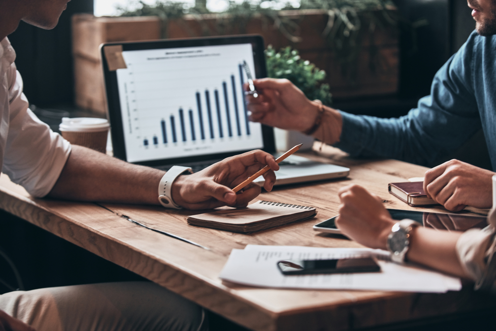 A group of people sitting at a table reporting on an increase in leads