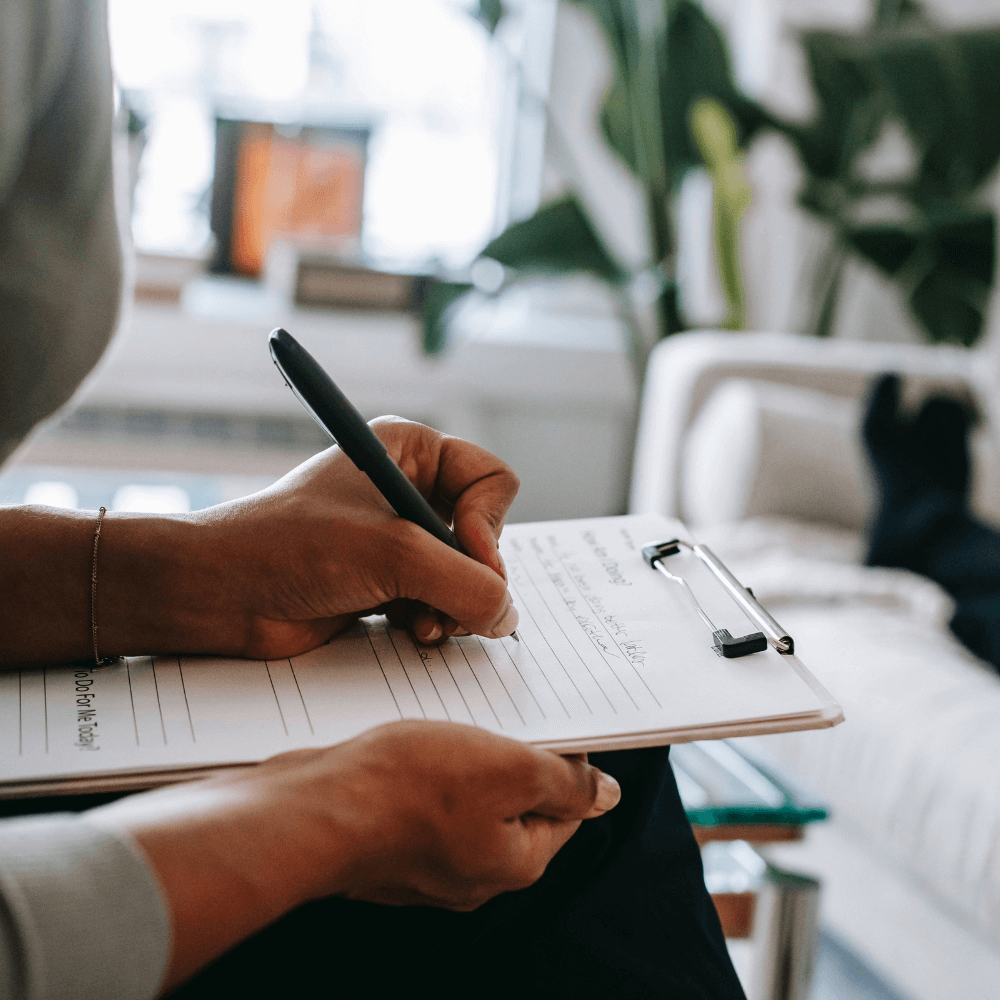 A doctor writing notes to represent how we tailor our mould treatment plans to your home