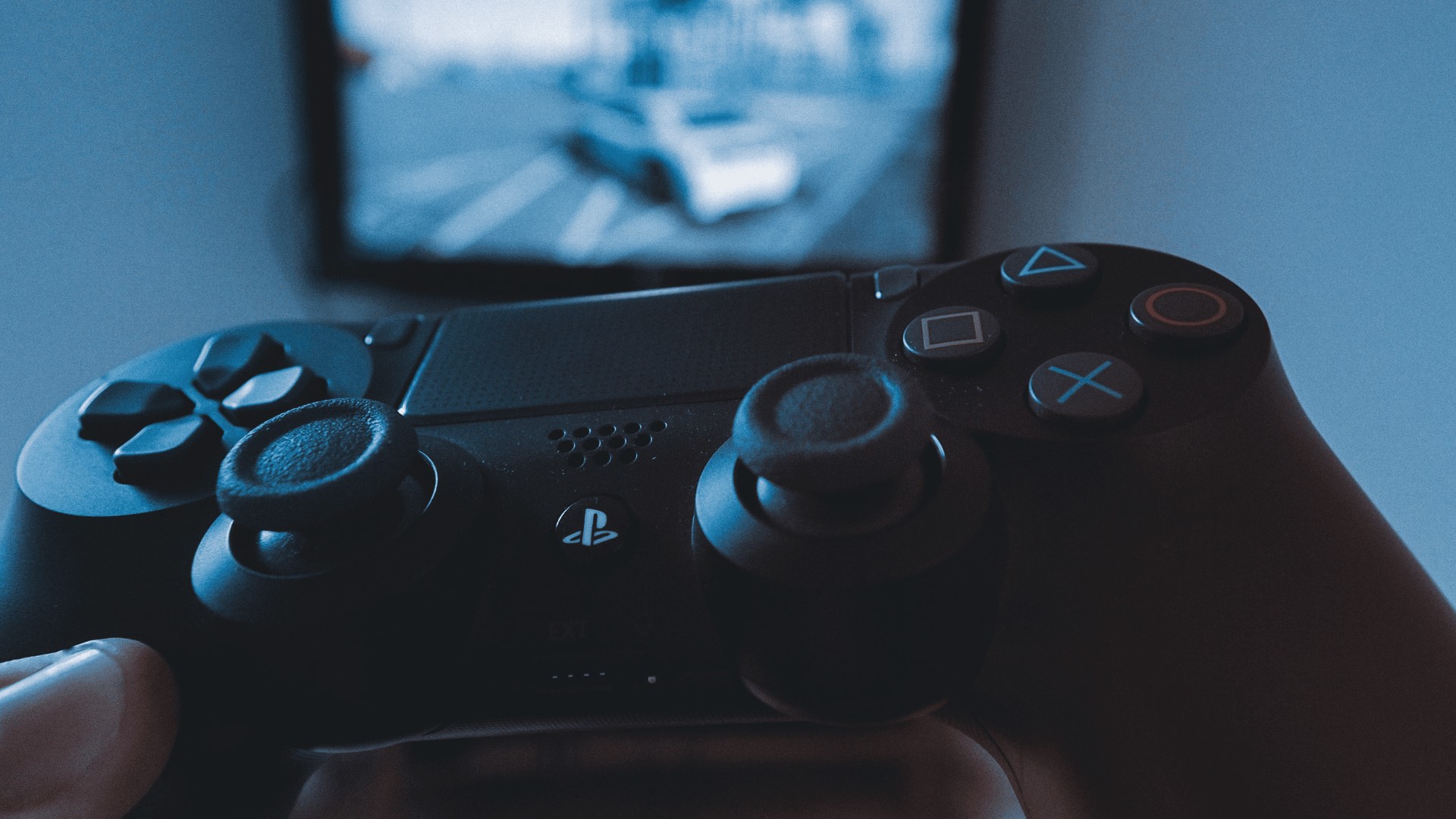 Person holding a Sony Playstation remote while playing a game