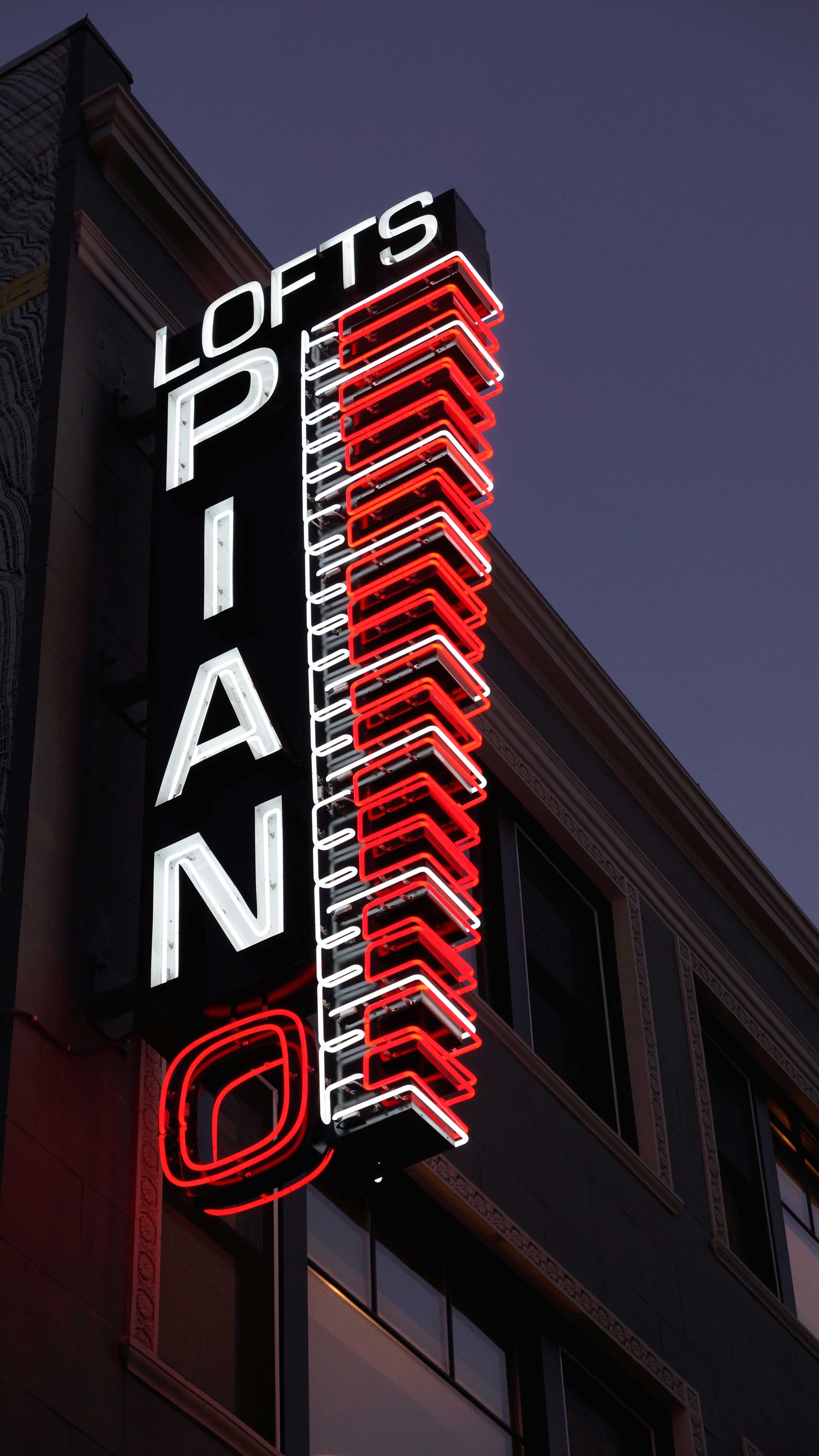 Piano Lofts neon illuminated blade sign.