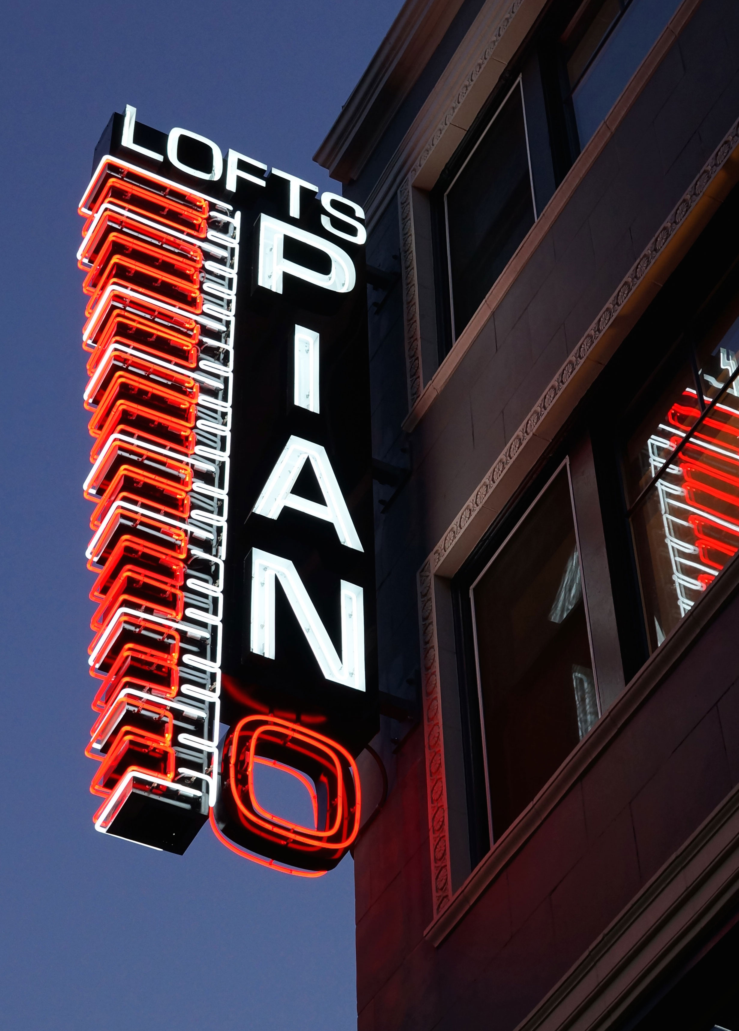 Piano Lofts neon illuminated blade sign.