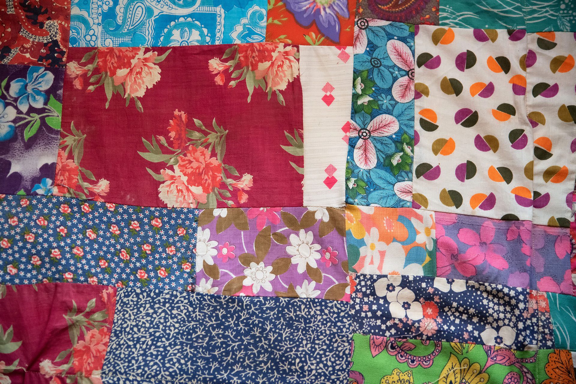 View of traditional hand-made patchwork quilt made of bright pieces