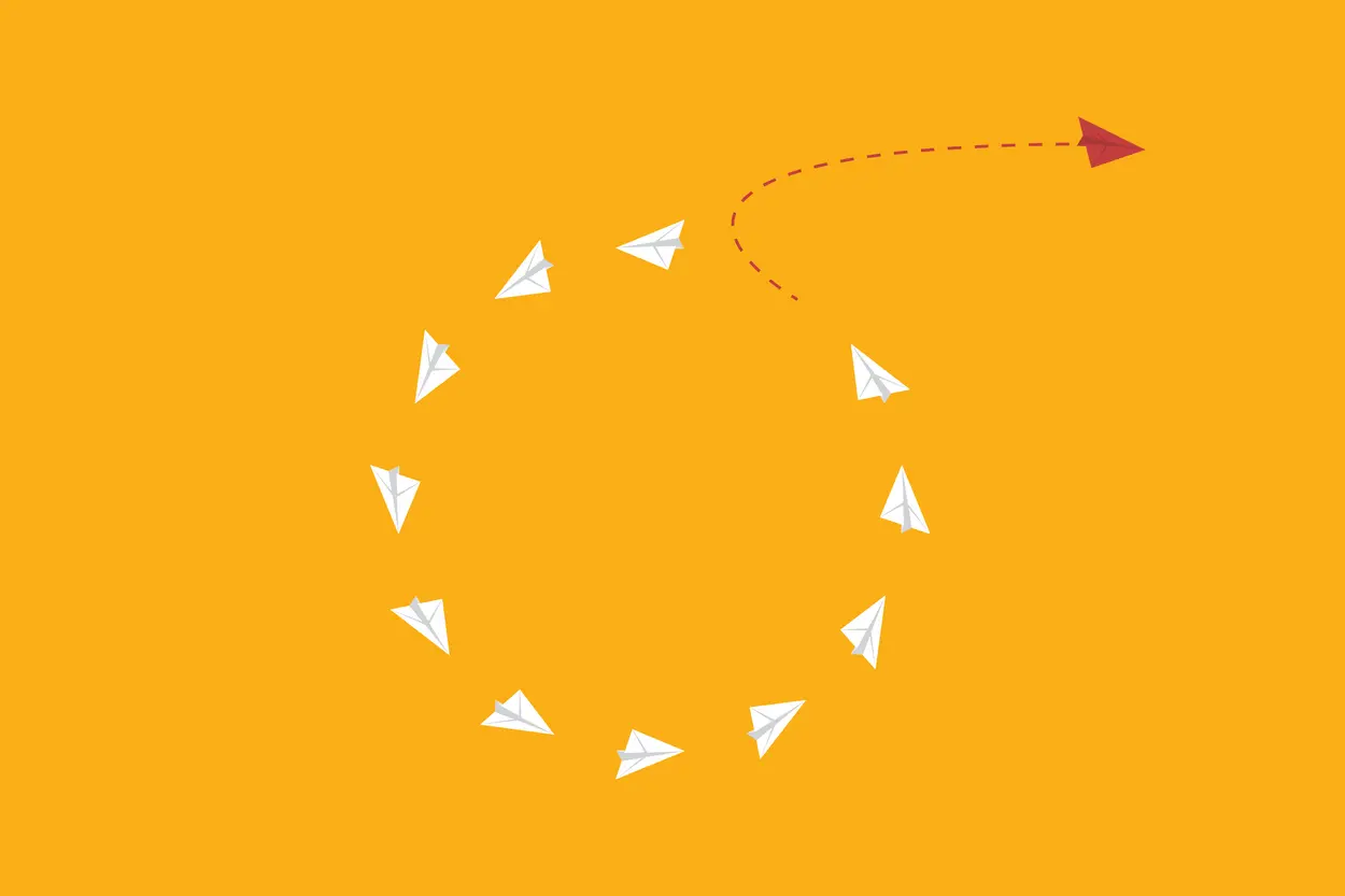 White paper plane loop in circle formation, while a red paper plane trails off to the right on its own path.
