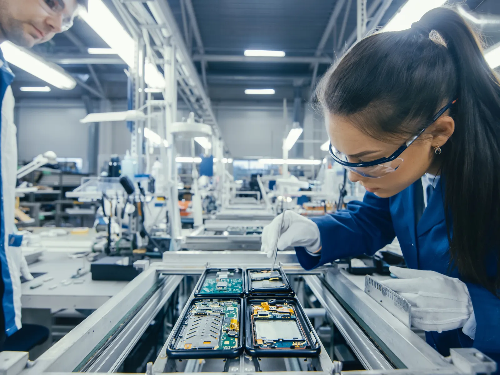 Factory worker inspecting smartphone chips