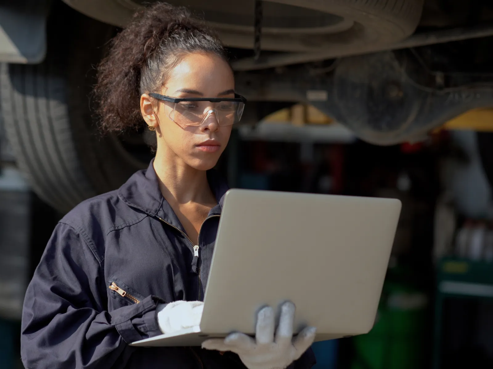 Factory inspector typing on a laptop while standing