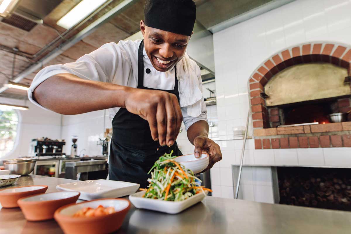Foto de um chefe preparando um prato de salada