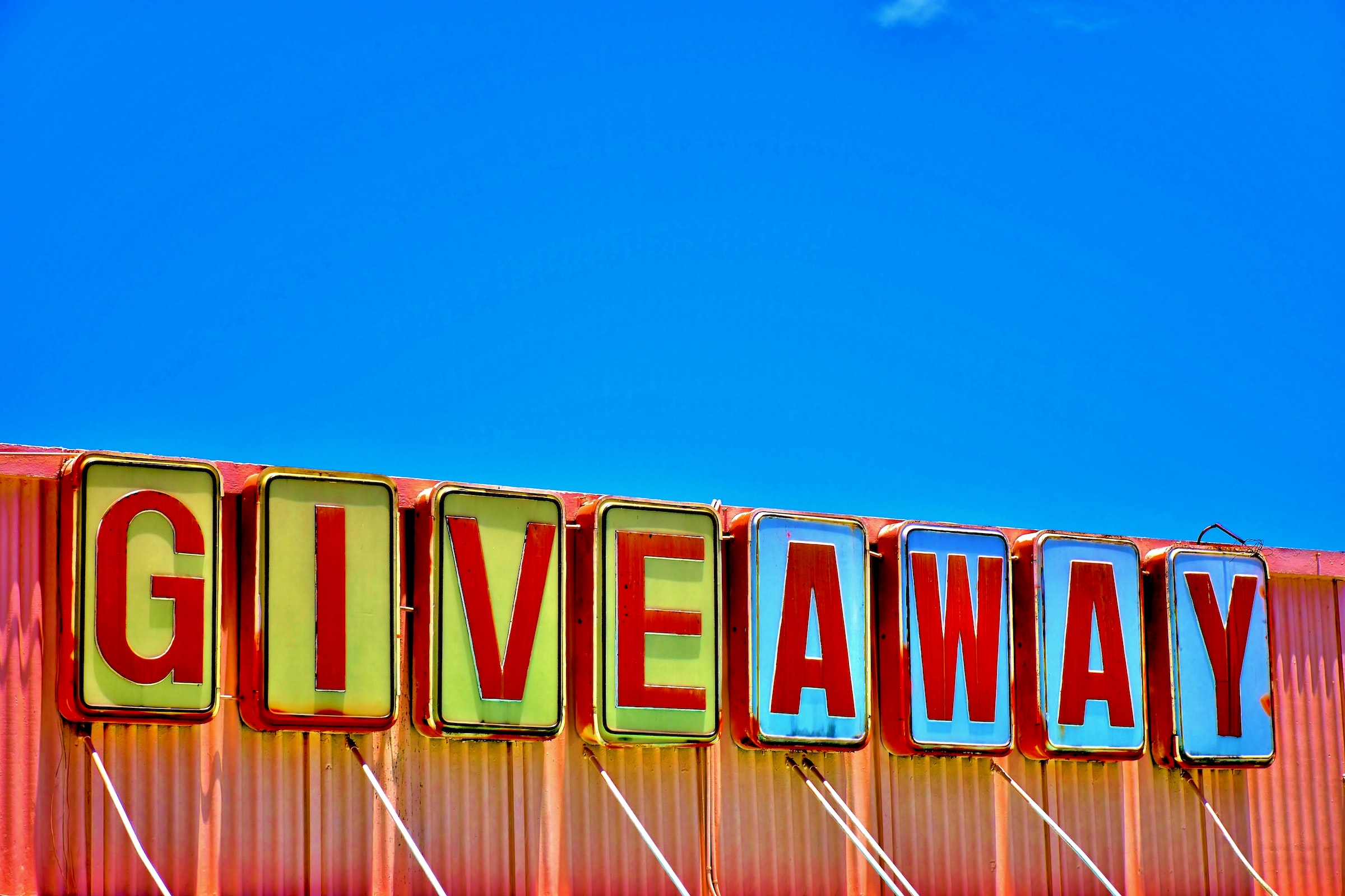 A big multicolored sign reading "GIVEAWAY."