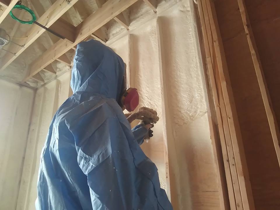 A Spray Foam Solutions specialist spraying a residential wall.