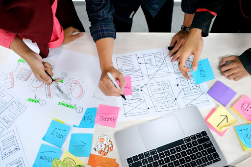 Vue du dessus de post-it colorés et de graphismes, de prises de note pour chercher à améliorer l’expérience collaborateur.