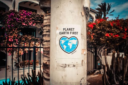Affiche “Planet earth first” sur un pilier en béton dans la rue.