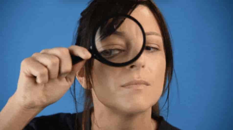 une femme regarde dans une loupe