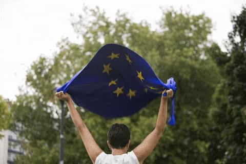 Une femme soulève le drapeau de l'UE dans son dos