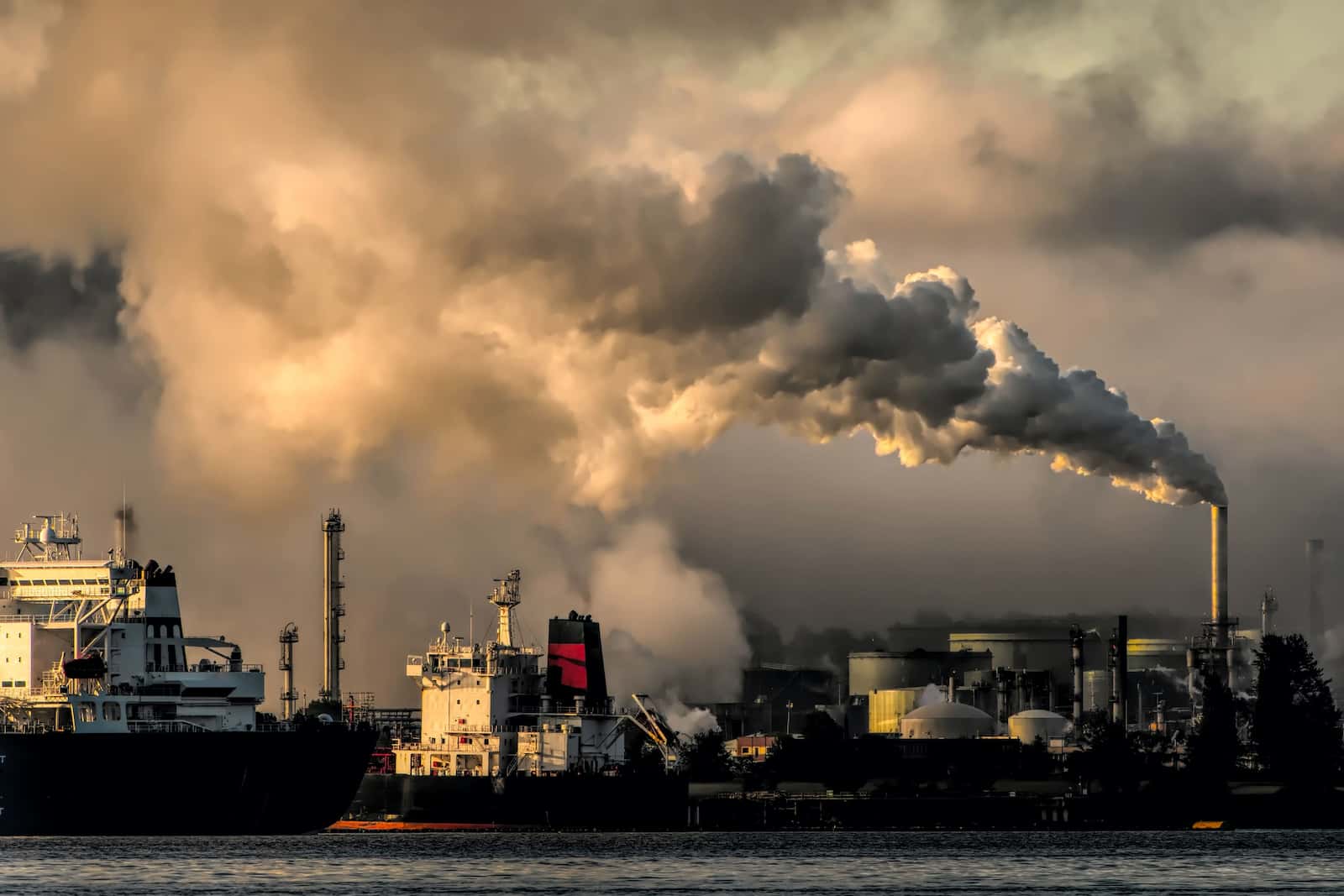 Exploitation de l'industrie pétrolière en train d'extraire des ressources avec de gros nuages polluants au dessus d'eux.