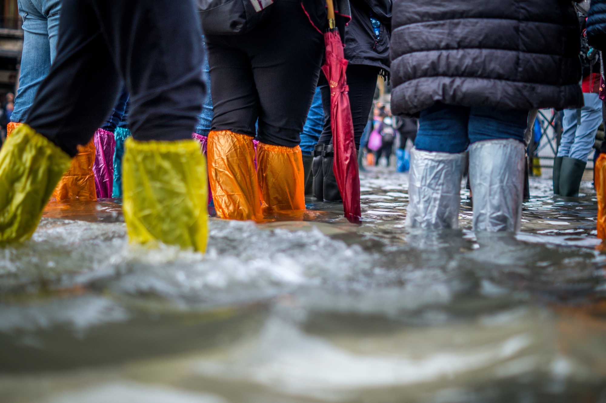 People in a flooded city wearing plastic around their legs to keep themselves dry
