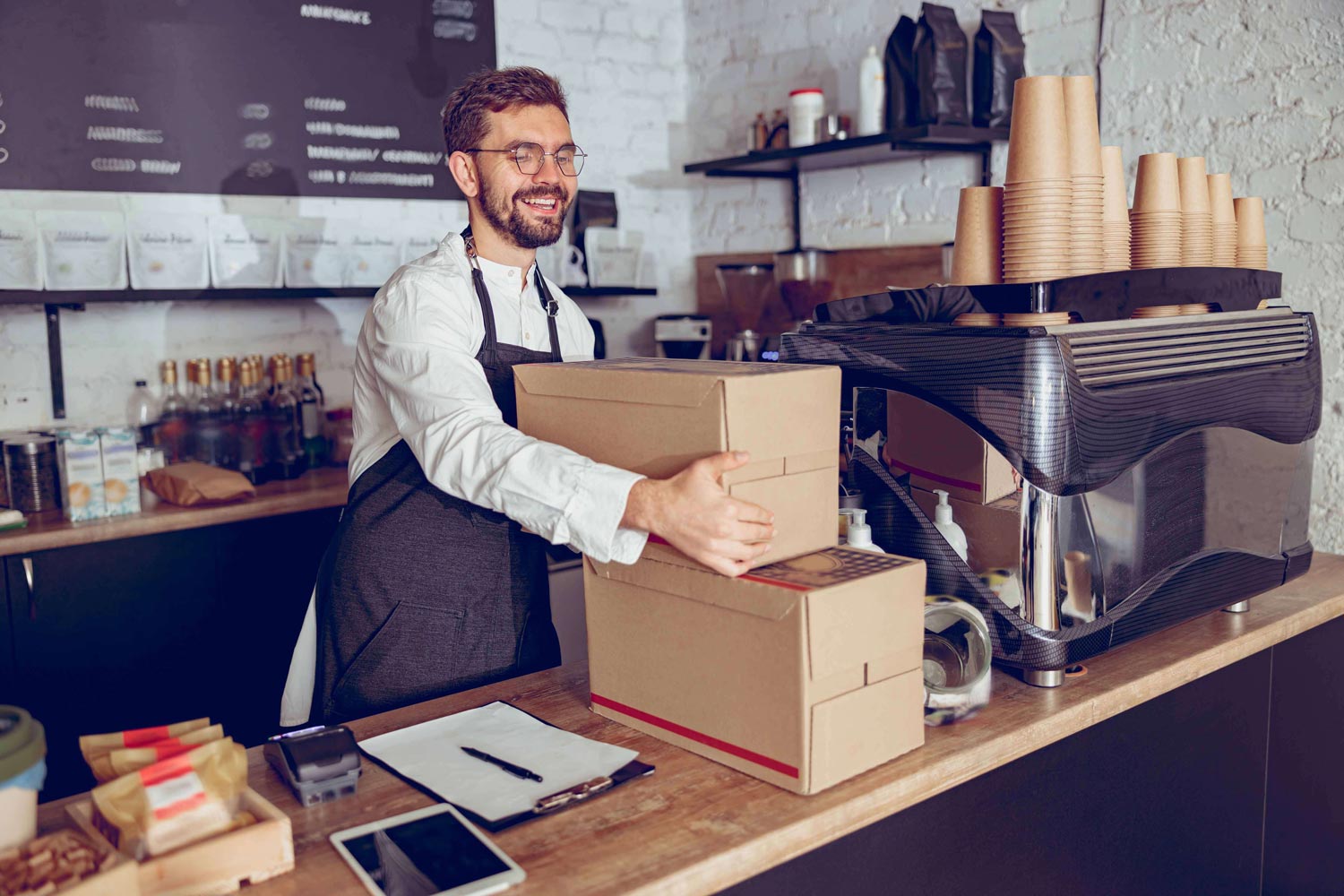 Homem carregando caixas de entrega de comida em um balcão de restaurante
