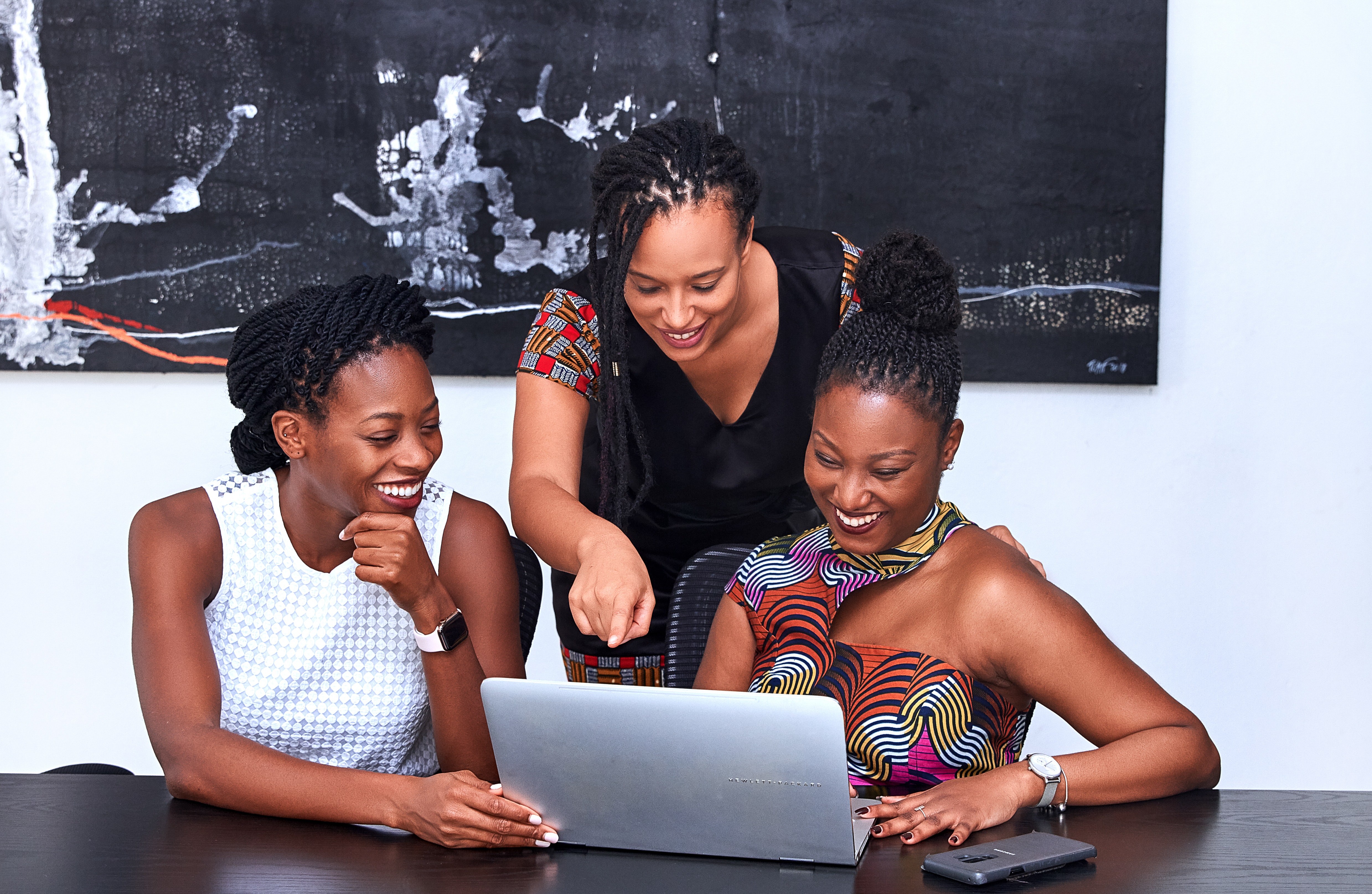 employees smiling in front of computer