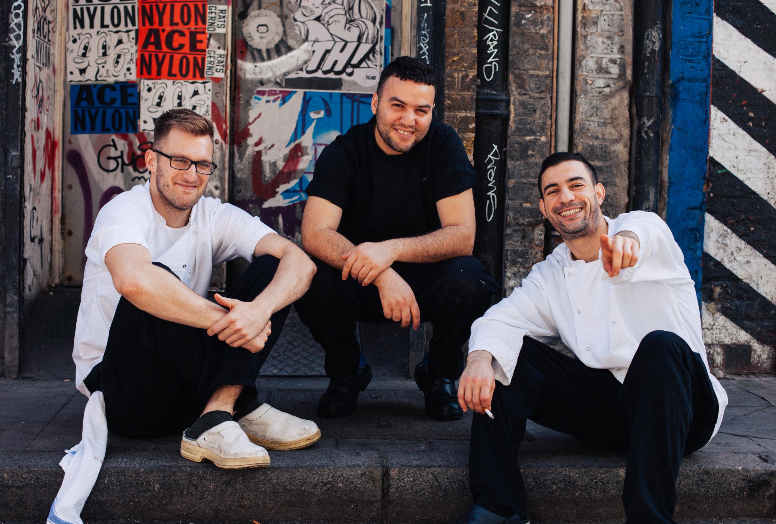 Group of men sitting on staircase smiling
