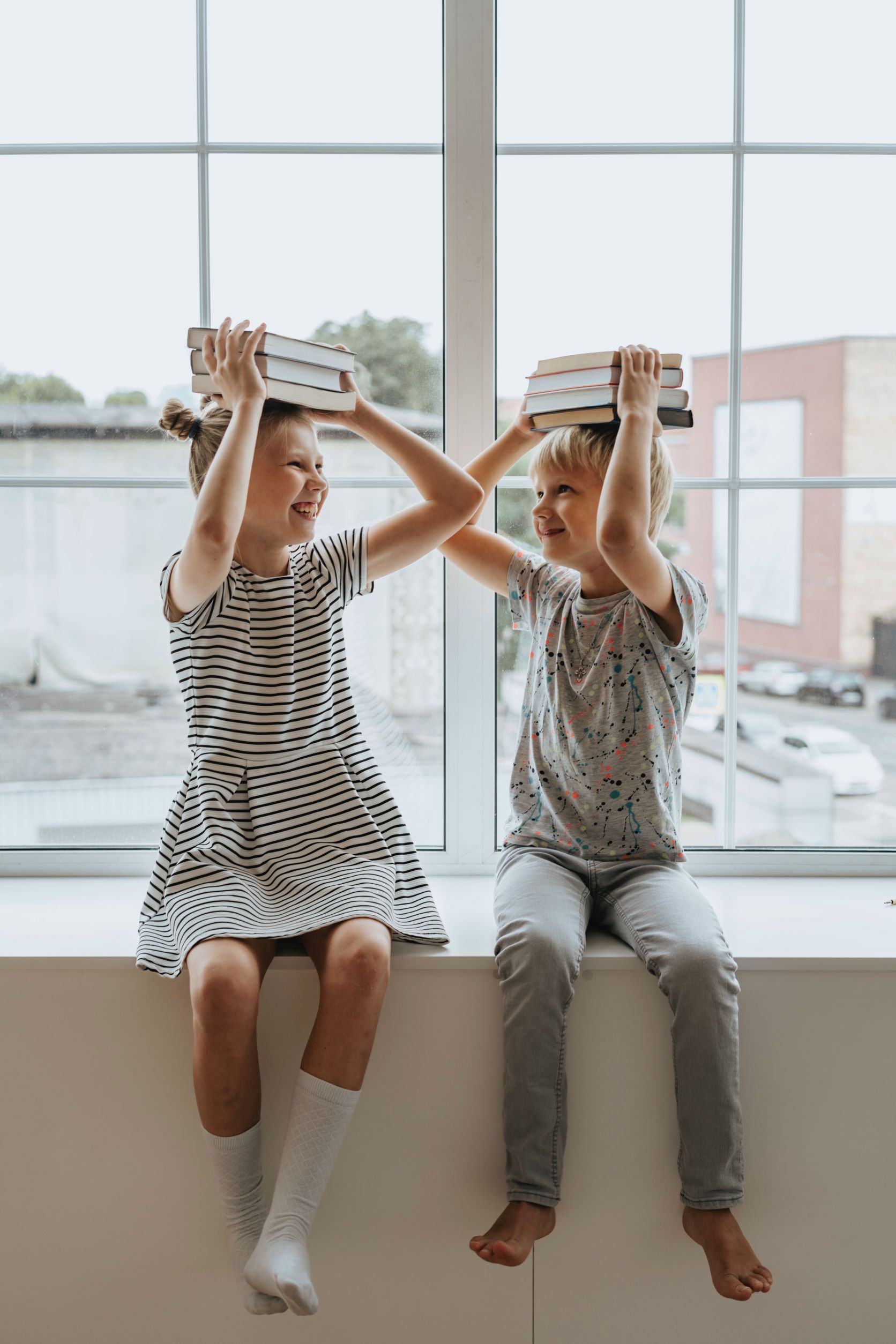 Two students balancing books on their heads