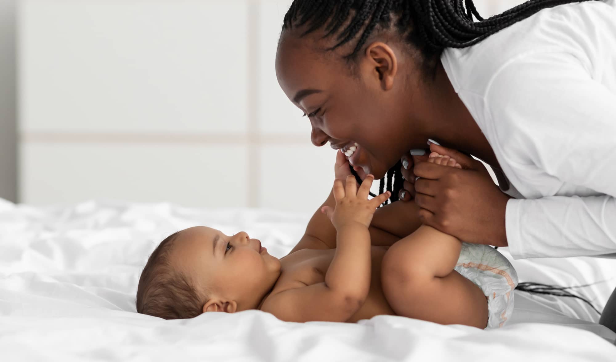 Mom playing with child in bed