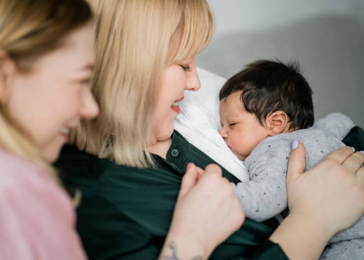 Two ladies holding a baby