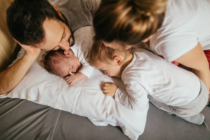 Family with baby in bed