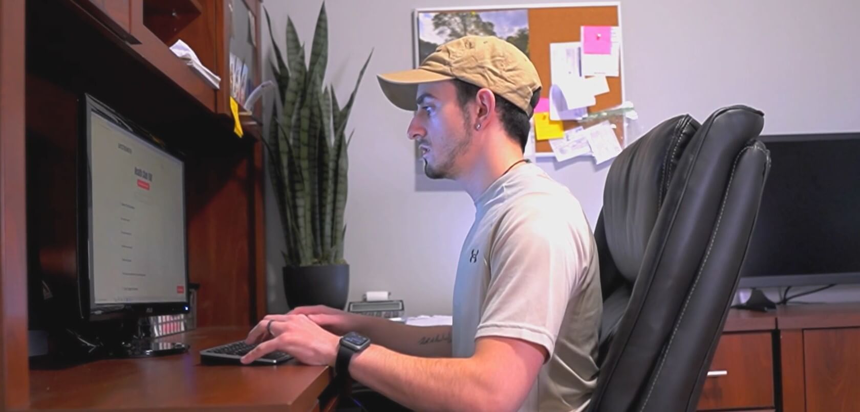 6 Exercises That Can Be Done at the Office - A man sitting at desk looking computer and typing on keyboard