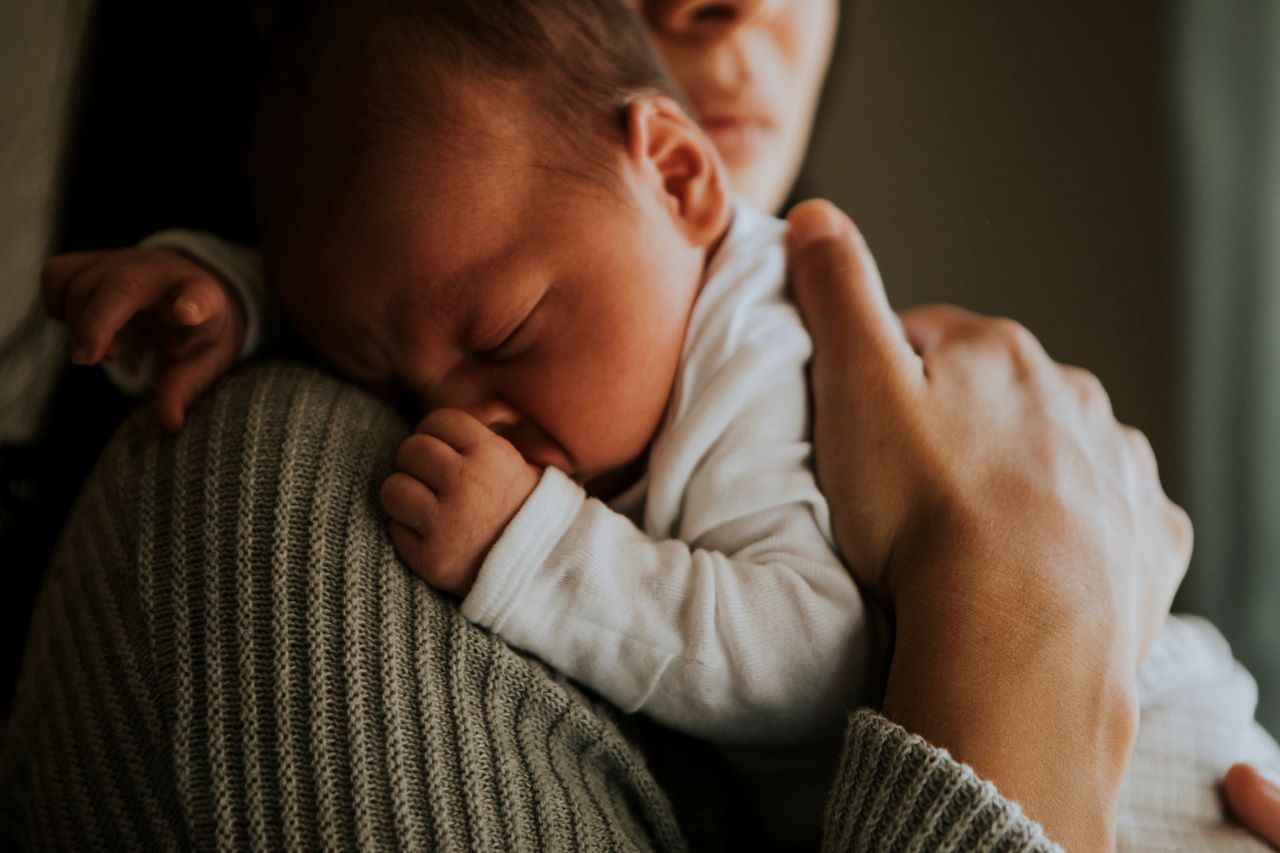 Mother holding her child indoors.