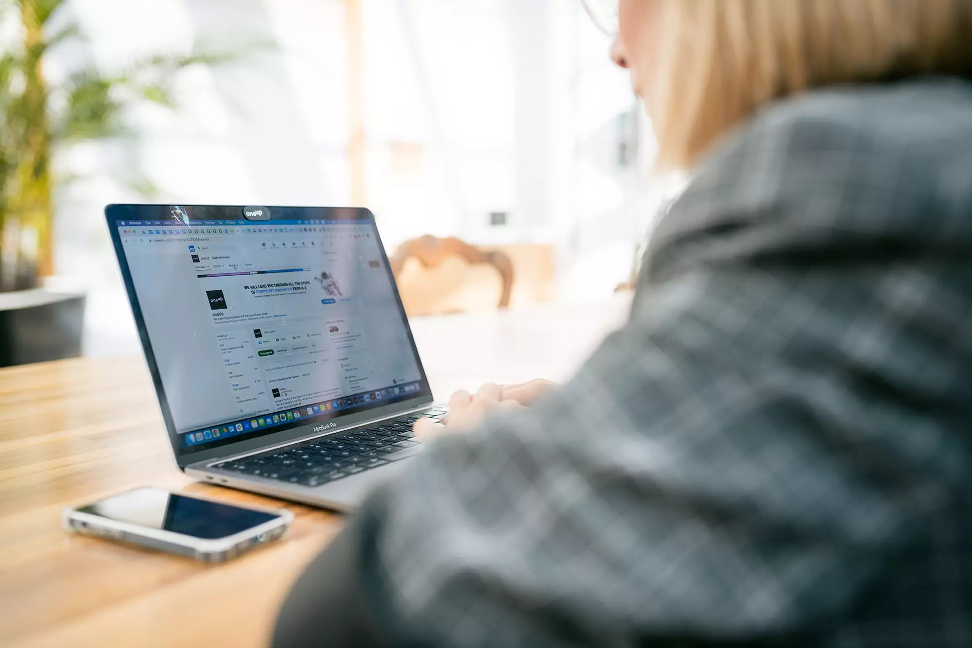 Young female employee looking at a LinkedIn Page on her laptop